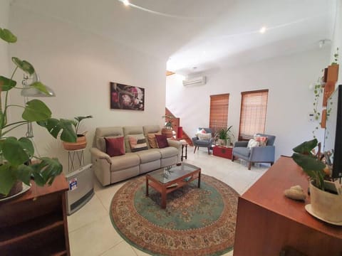 Relax into plush seating surrounded by greenery and warm light, creating an inviting space for slow mornings or cosy evenings in.