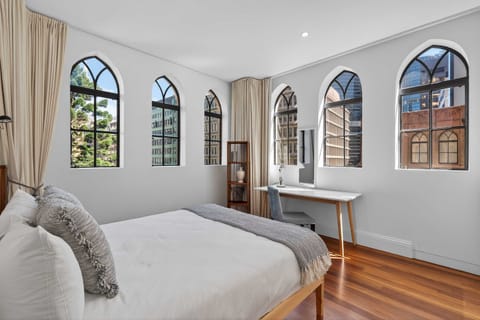 Stylish entry-level bedroom featuring a queen bed, dual wardrobes, and a dedicated workspace. Comfort meets functionality just steps from the bathroom.
