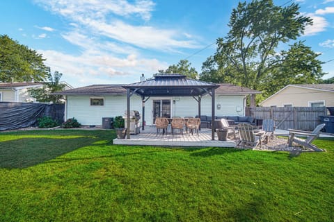 Spacious fenced backyard with deck, Adirondack chairs, and outdoor dining - perfect for grilling, lounging, and making memories under the stars. 