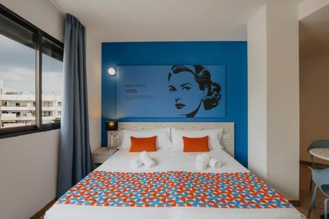 Unwind in crisp linens beneath bold, playful designer artwork.