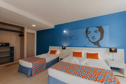 Unwind in bright twin beds beneath iconic blue artwork.