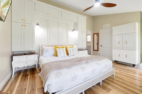 Enjoy a restful stay in this bright and airy bedroom featuring a comfortable King-size bed, elegant built-in cabinetry, and beautiful hardwood floors.