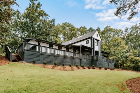 Spacious home with a large wraparound deck and peaceful wooded surroundings.