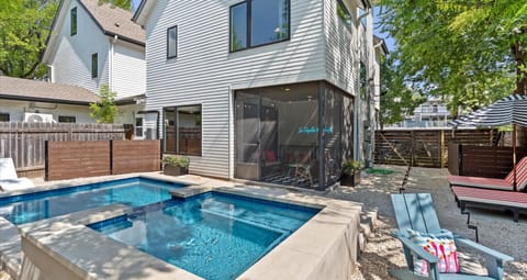 Private outdoor pool with striped sun loungers and umbrellas