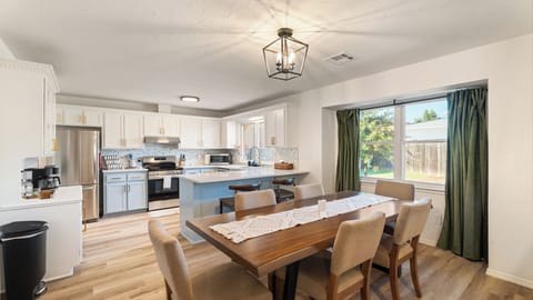 Cook, dine, and connect in this open-concept kitchen featuring stainless steel appliances, sleek cabinetry, and a bright dining area overlooking the backyard — a perfect space for shared meals and conversation.