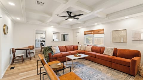 Gather and unwind in this airy living room featuring a plush sectional, cozy accents, and seamless flow into the kitchen and dining areas — perfect for family time or entertaining friends.