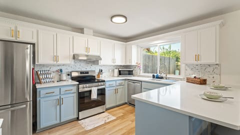 Cook with ease in this bright, updated kitchen featuring stainless steel appliances, quartz countertops, and plenty of cabinet space — complete with all the essentials for your stay.
