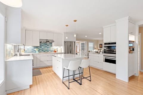 Discover your dream kitchen with sleek white cabinets, granite countertops, and modern appliances perfect for preparing memorable meals during your stay.