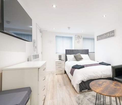Comfortable double bed and seating area in a light-filled studio.