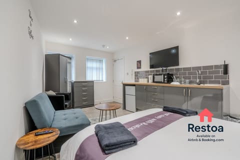 Open-plan studio with bed, sofa, and kitchen area