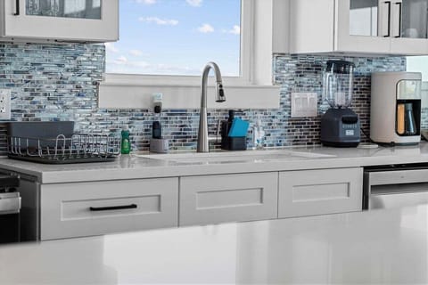 Bright coastal kitchen with quartz countertops, custom cabinetry, and modern fixtures.