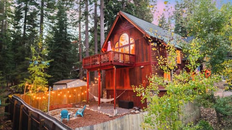 Backyard oasis featuring a fire pit, seating and a hammock for ultimate relaxation. 