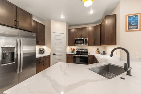 Full kitchen with stainless steel appliances and breakfast bar seating for 4.