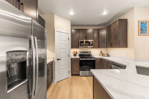 Full kitchen with stainless steel appliances and breakfast bar seating for 4.