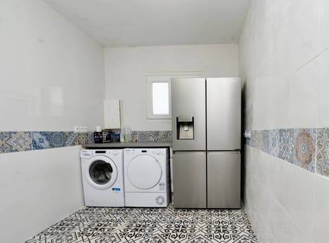 Fully equipped laundry area with washing machine, dryer, and large american stye fridge freezer with an ice dispenser. Conveniently located in the utility bathroom, ideal for longer stays