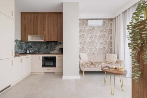 A modern kitchenette with wooden cabinets and all essential appliances. Compact yet stylish for daily cooking.