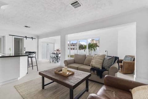 Cozy and bright living room with comfy seating and smart TV — perfect for relaxing after a beach day.