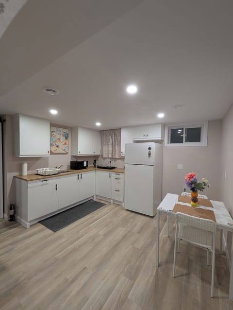 Kitchenette equipped with microwave, water kettle, fridge & induction cooktop.