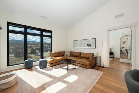 Relax in your sun-drenched living room with premium leather seating and stunning mountain views through floor-to-ceiling windows.