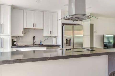 Modern kitchen featuring stainless steel appliances and full cooking supplies.