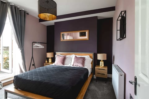 Modern double bedroom with deep purple feature wall