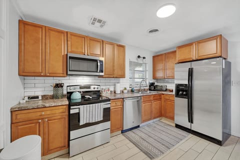 Modern kitchen with coffee maker, oven, stovetop, microwave, and refrigerator