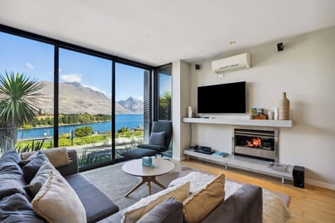 Sunlit living space with floor-to-ceiling windows, opening out to stunning alpine views. The perfect spot to relax after a day exploring Queenstown.