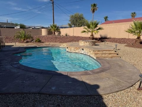 Private backyard oasis with sparkling pool and desert landscaping