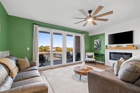 A ceiling fan overhead adds breezy comfort, while the oversized flat-screen TV anchors the room for movie nights or catching the big game.