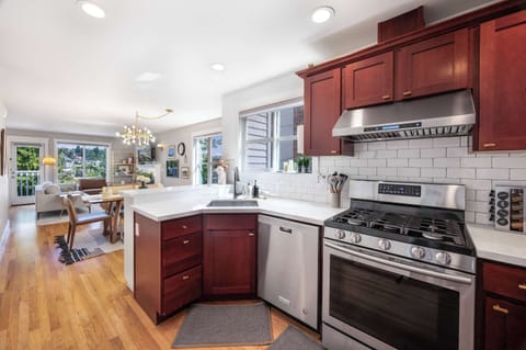Cook with ease in a fully equipped kitchen featuring stainless steel appliances and rich wood cabinetry, seamlessly connected to the dining and living areas.