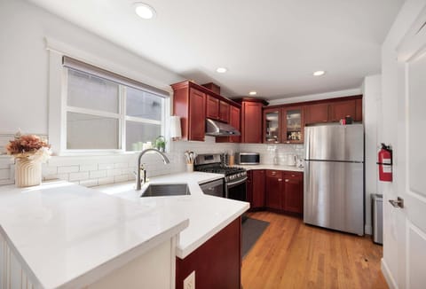 Bright, modern kitchen with marble countertops, subway tile backsplash, and stainless appliances.
