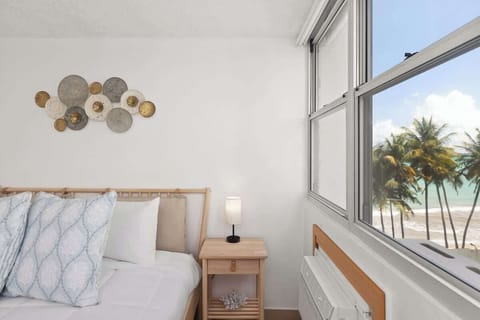 room with beachfront beach views, bed and wall art