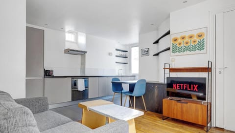 Pièce de vie avec canapé, espace repas et TV.​