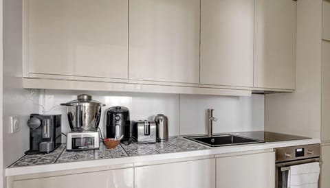 Cuisine fonctionelle : rangements, machine à café et four.