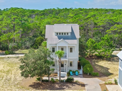 Front exterior of the home surrounded by lush greenery.
