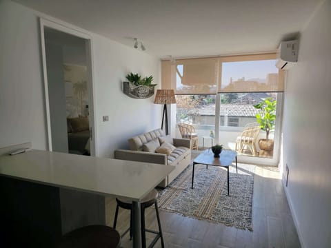 Bright and cozy living area with a charming balcony view, perfect for relaxation in this stylish studio apartment.