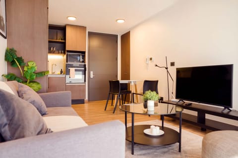 Cozy modern living room with kitchenette and dining area, perfect for relaxing after a day of exploring.