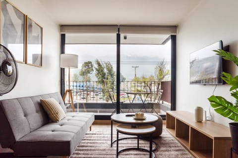 Enjoy breathtaking mountain views from a chic living room with a cozy balcony, perfect for relaxation.