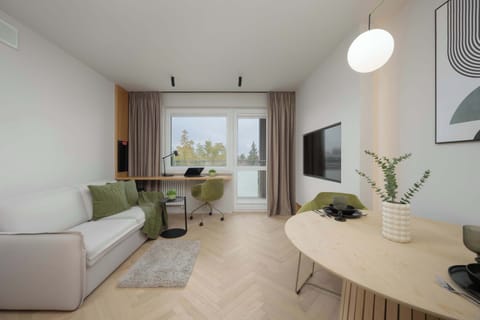 The bright living room with a large window and soft sofa offers plenty of natural light, creating a perfect space to unwind after a day of exploring the city.