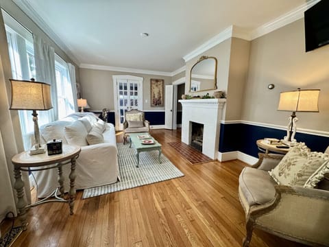 Comfortable living room with smart TV and access to front entrance, dining room, and side porch.