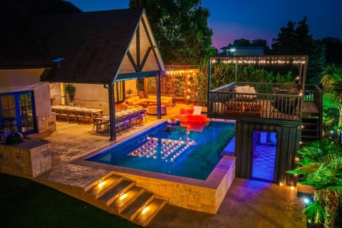 This is what a real getaway looks like. The illuminated pool, fire pit pavilion, and two-story karaoke bar glow at twilight at this DFW Airbnb estate. Built for large group celebrations and retreat weekends in Texas.
