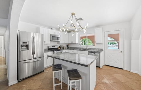 This modern kitchen features stainless steel appliances, sleek granite countertops, and a central island perfect for morning coffee or evening cocktails.