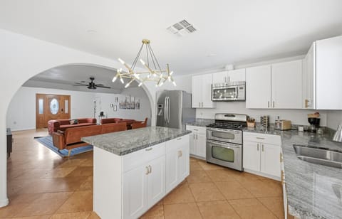 This modern kitchen features stainless steel appliances, sleek granite countertops, and a central island perfect for morning coffee or evening cocktails.