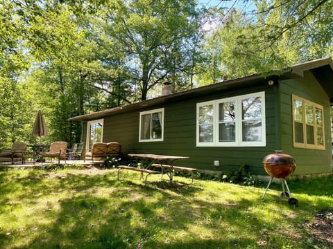 Lake facing side of house. Patio with furniture, picnic table, two grills. 