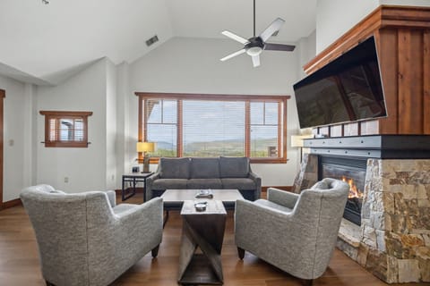 Open-concept living space with fireplace and mountain views.