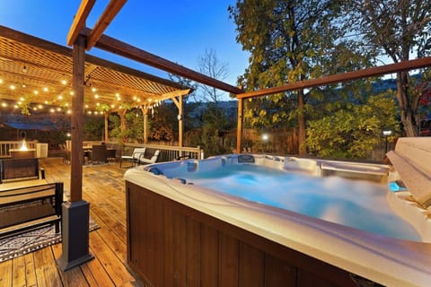 Unwind in the outdoor hot tub surrounded by twinkling lights and nature.