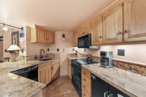 Full kitchen with a breakfast bar, seating 2.