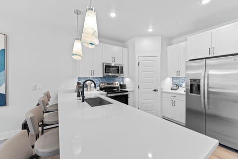 Full kitchen with stainless steel appliances and breakfast bar seating