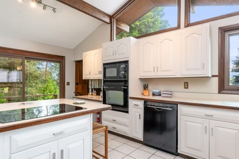 Bright and spacious kitchen featuring vaulted ceilings, modern appliances, and a cozy coffee station—perfect for cooking and gathering.