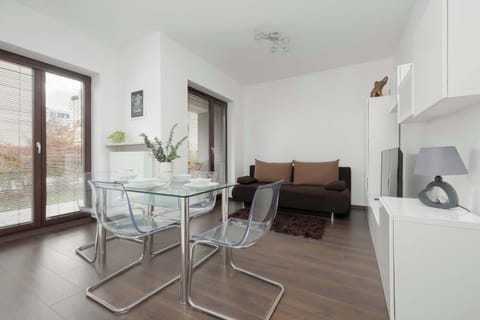Bright living area with glass doors leading to the balcony invites you to enjoy your morning coffee surrounded by natural light and a calm view of greenery.